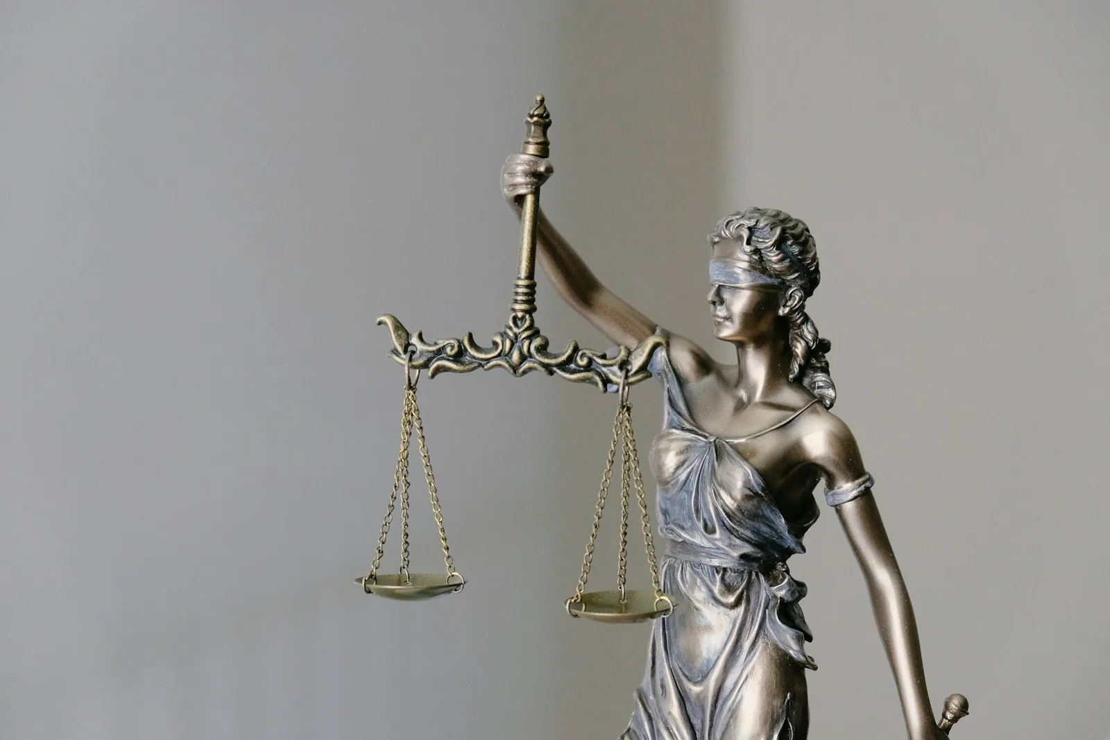 Statue allégorique de la Justice tenant sa balance, sur fond clair, évoquant le cadre légal du Règlement UE 2024/1689.