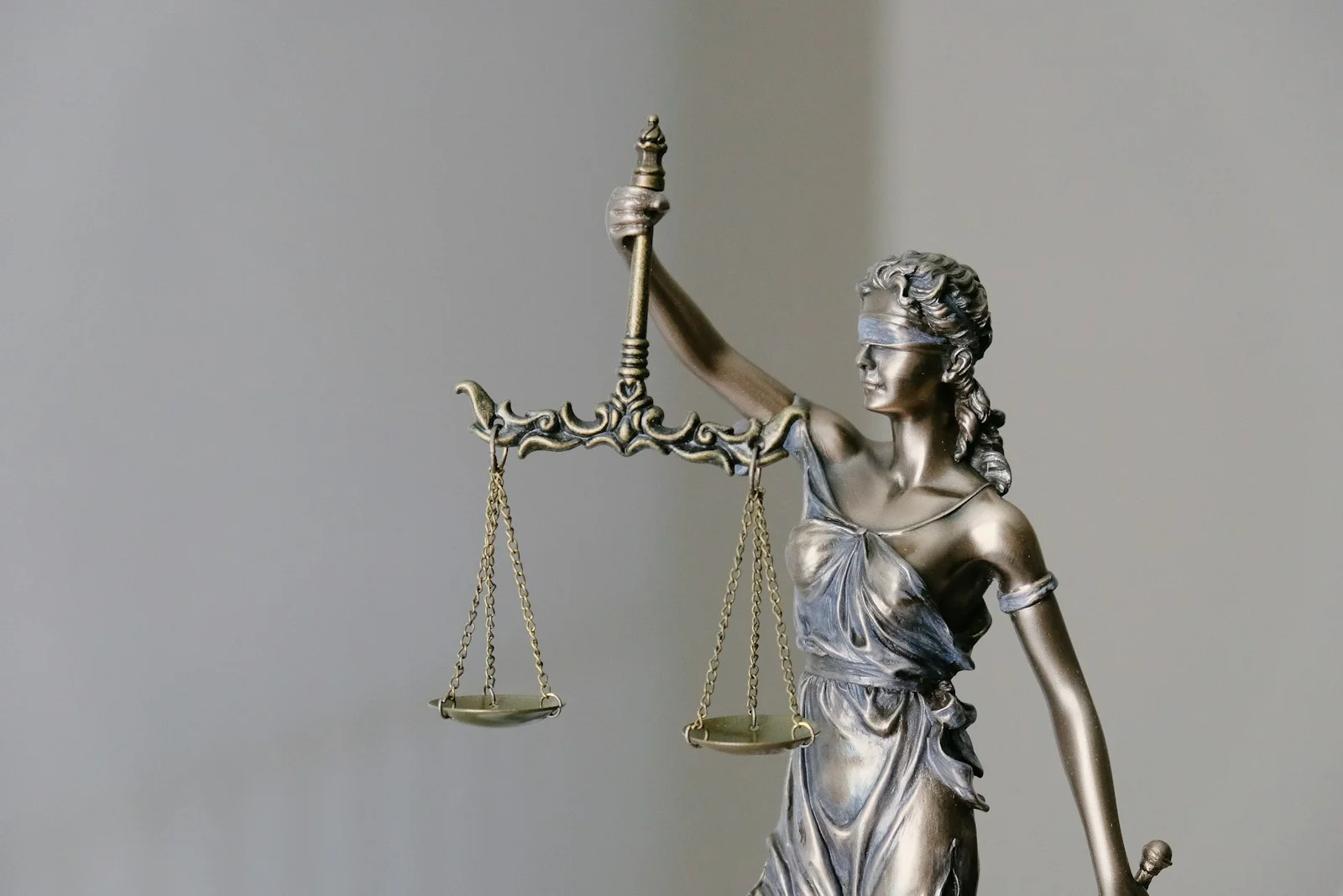 Statue allégorique de la Justice tenant sa balance, sur fond clair, évoquant le cadre légal du Règlement UE 2024/1689.