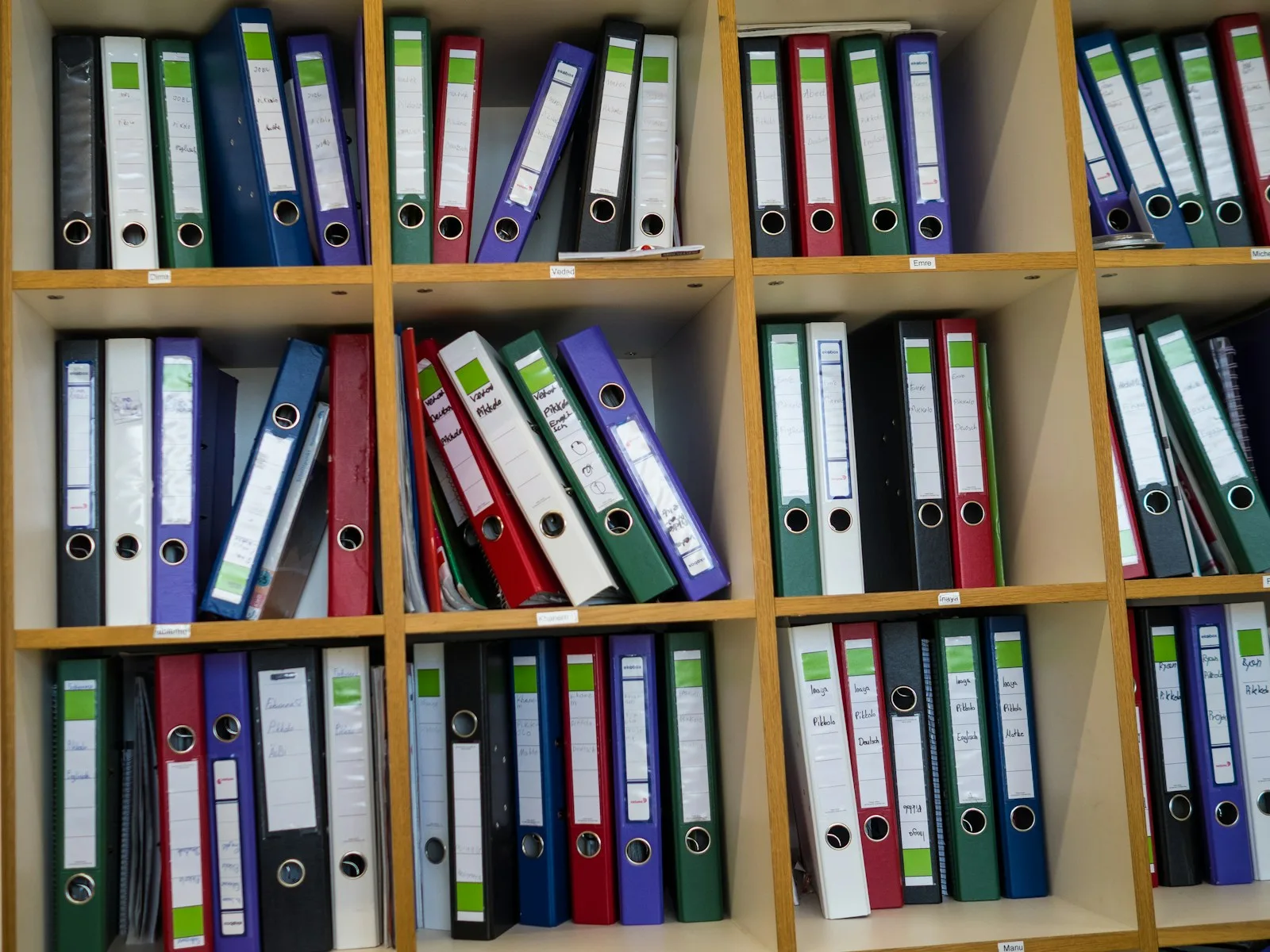 Etagere de bureau remplie de classeurs colores, comme un dossier de financement a trier.