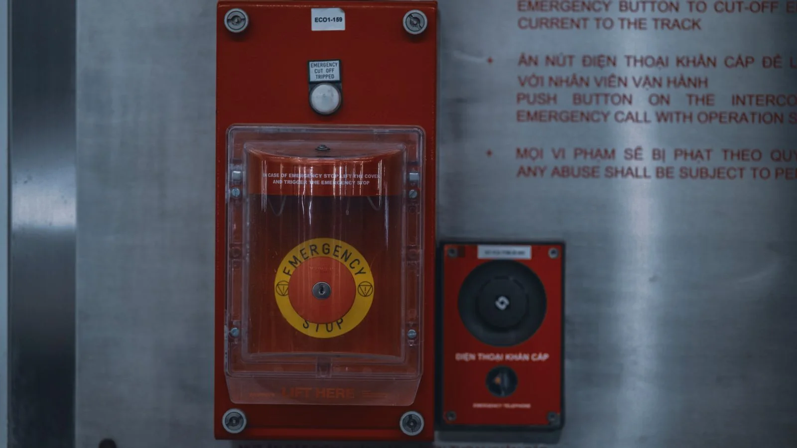 Bouton d’arrêt d’urgence rouge sur un panneau industriel métallique.