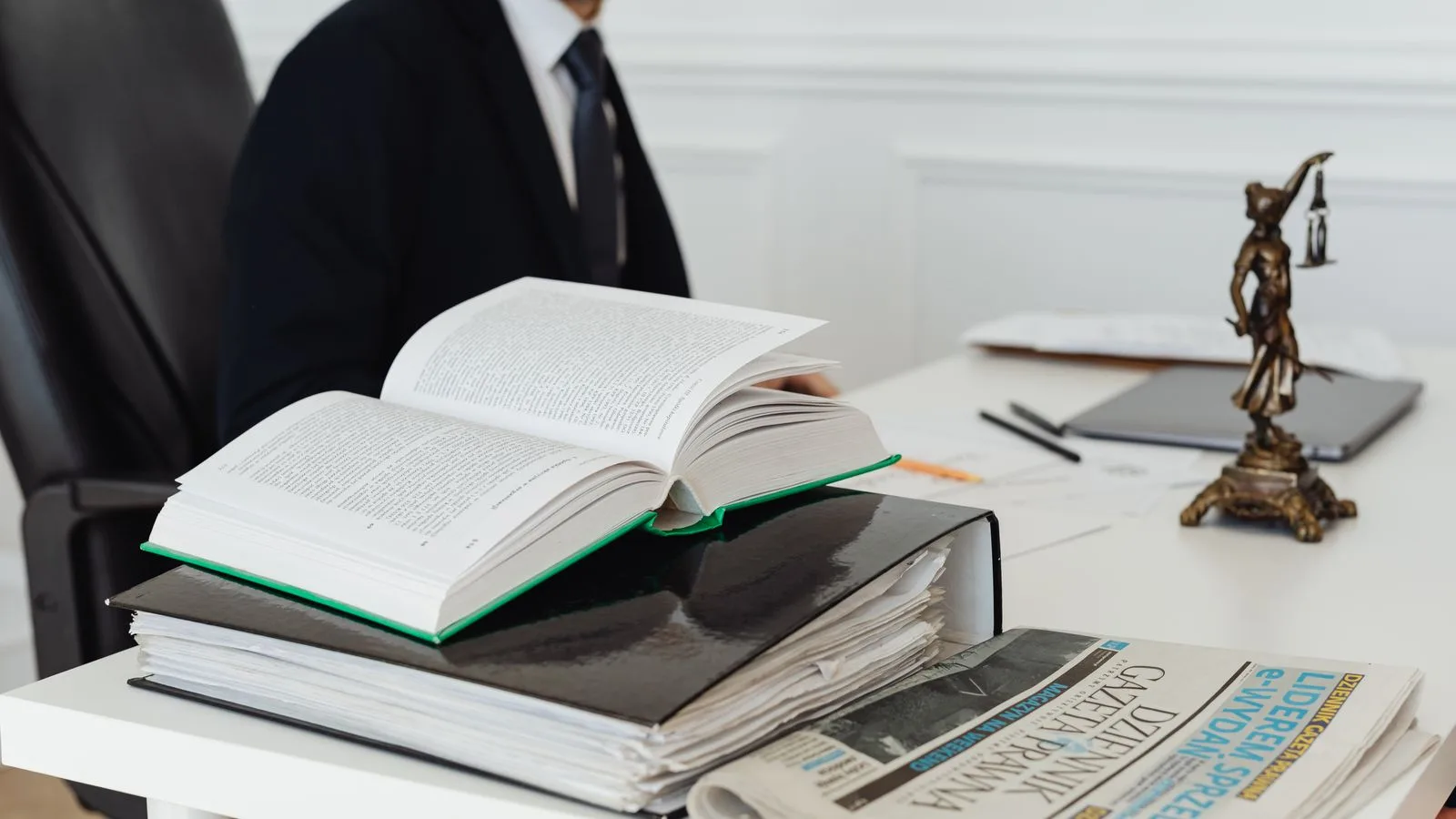 Livre juridique ouvert et dossiers de travail sur un bureau, symbole d'une classification AI Act à documenter.