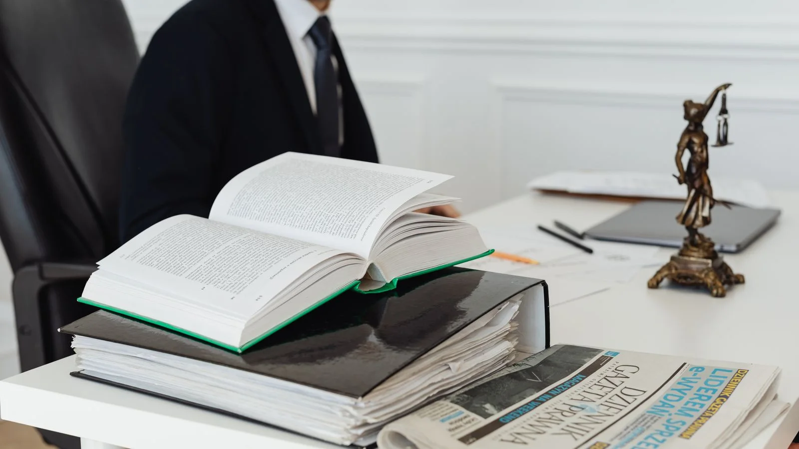Livre juridique ouvert et dossiers de travail sur un bureau, symbole d'une classification AI Act à documenter.