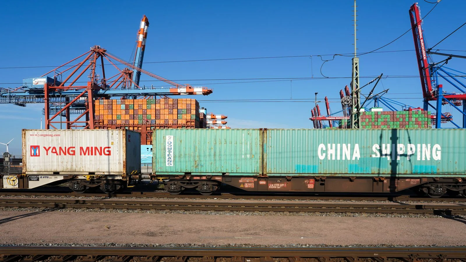 Conteneurs de fret chargés sur un train dans un terminal portuaire européen.