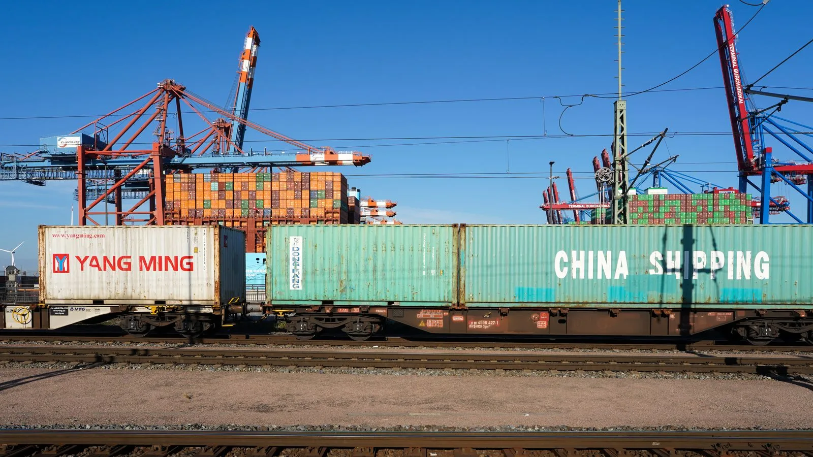 Conteneurs de fret chargés sur un train dans un terminal portuaire européen.