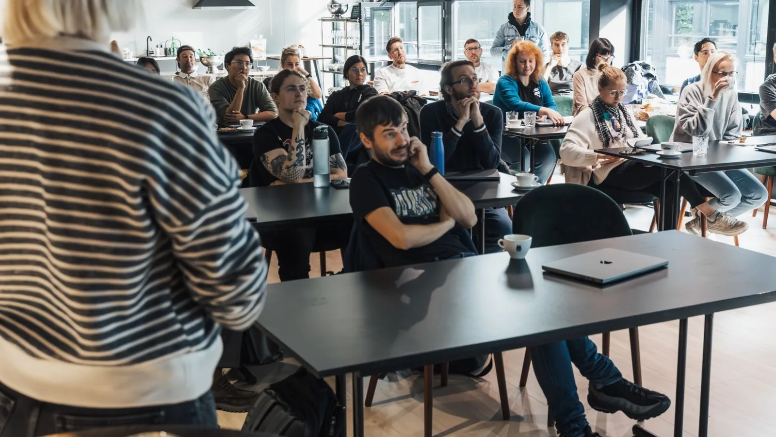 Adultes assis dans une salle de formation professionnelle pendant une presentation.