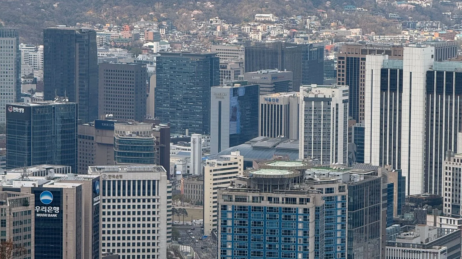Vue aérienne du quartier d’affaires de Séoul devant les montagnes.