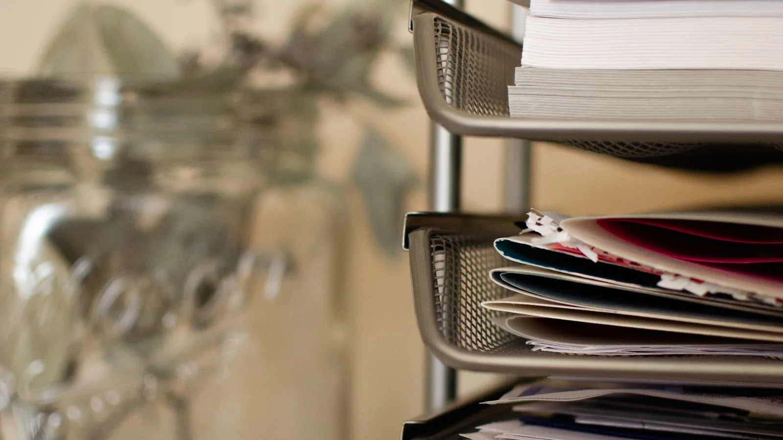 Piles de documents dans un bac de bureau, symbole d'un tri nécessaire avant de labelliser les contenus générés par IA.