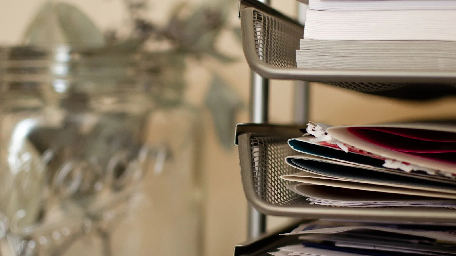 Piles de documents dans un bac de bureau, symbole d'un tri nécessaire avant de labelliser les contenus générés par IA.