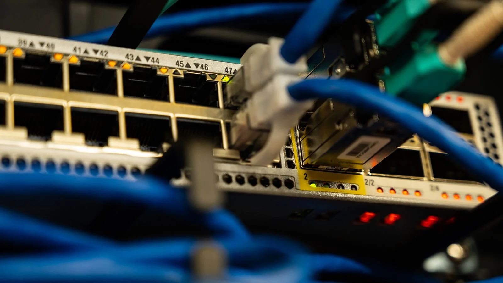 Câbles réseau branchés dans un équipement informatique, symbole des dépendances techniques à sécuriser avant un projet IA.