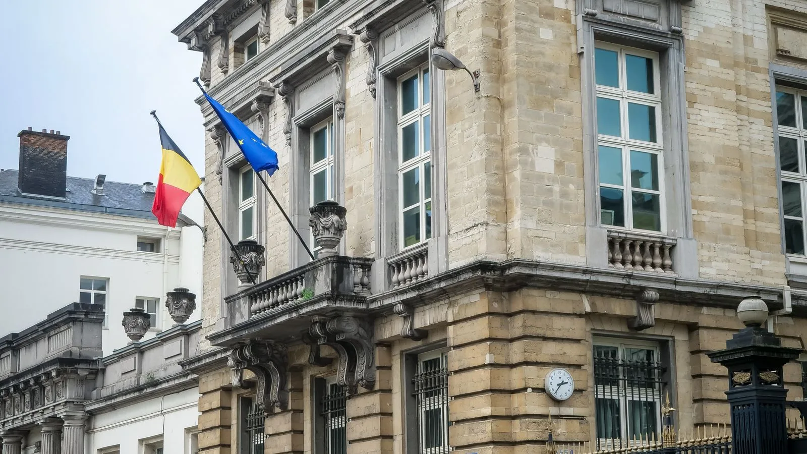 Façade du Parlement fédéral belge à Bruxelles avec les drapeaux belge et européen.