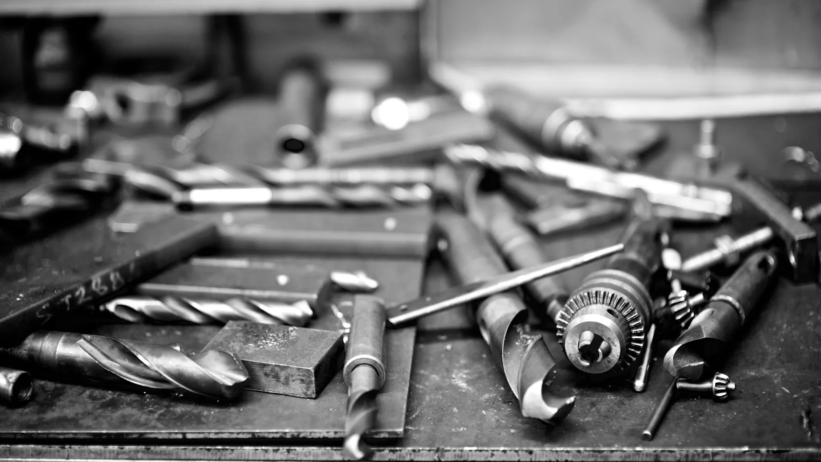 Forets et outils de maintenance disposés sur un établi d'atelier.