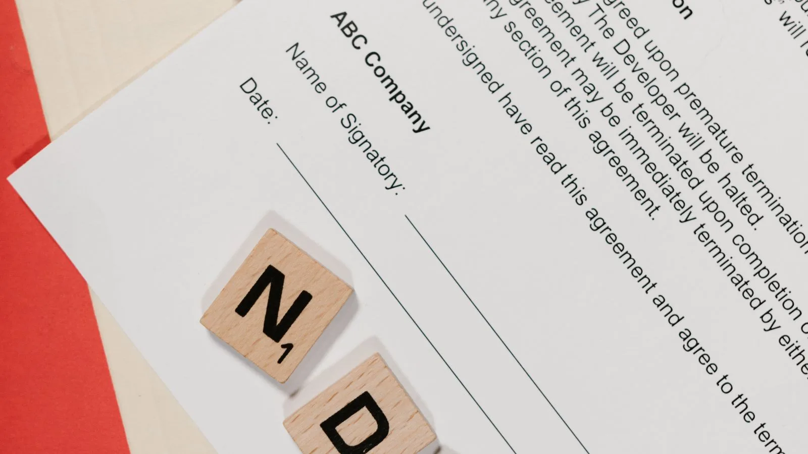 Document contractuel posé sur un bureau avec un stylo noir et un dossier rouge.