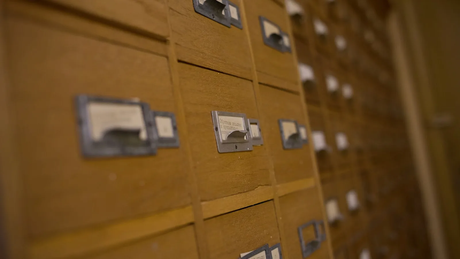 Meuble d’archives en bois composé de tiroirs étiquetés et alignés.