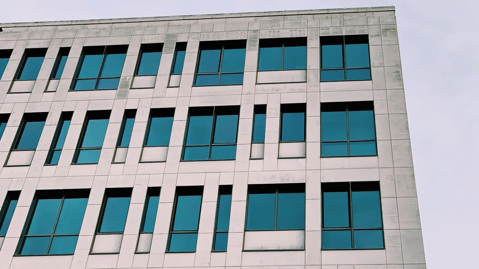 Facade moderne d'un immeuble de bureaux a Bruxelles, sous un ciel bleu.