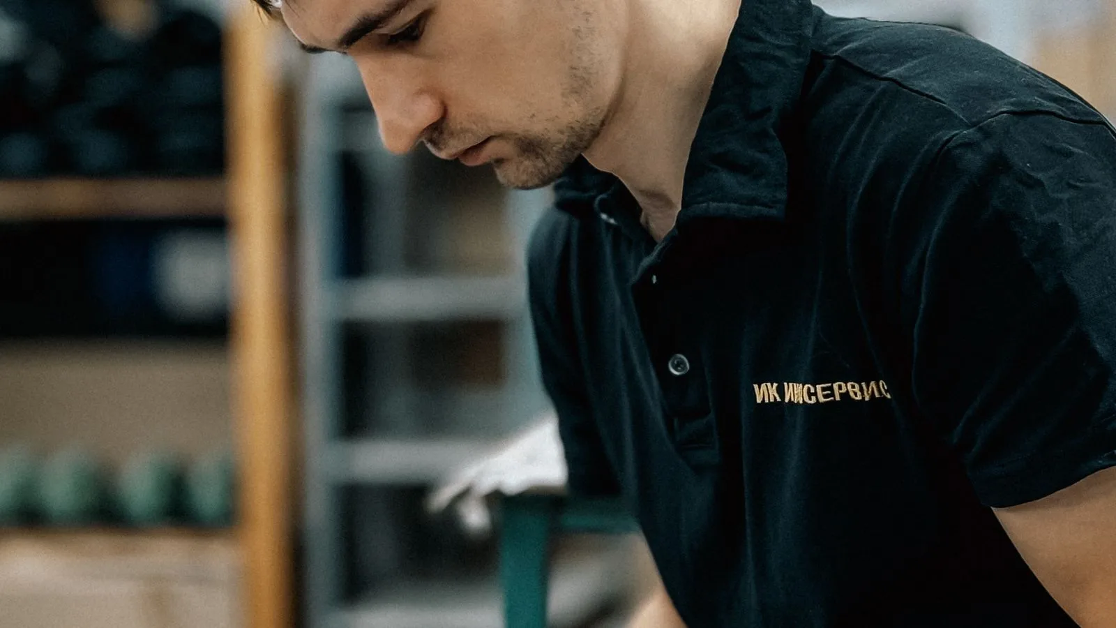 Technicien travaillant sur une tablette dans un atelier, entre stock, outils et donnees de terrain.