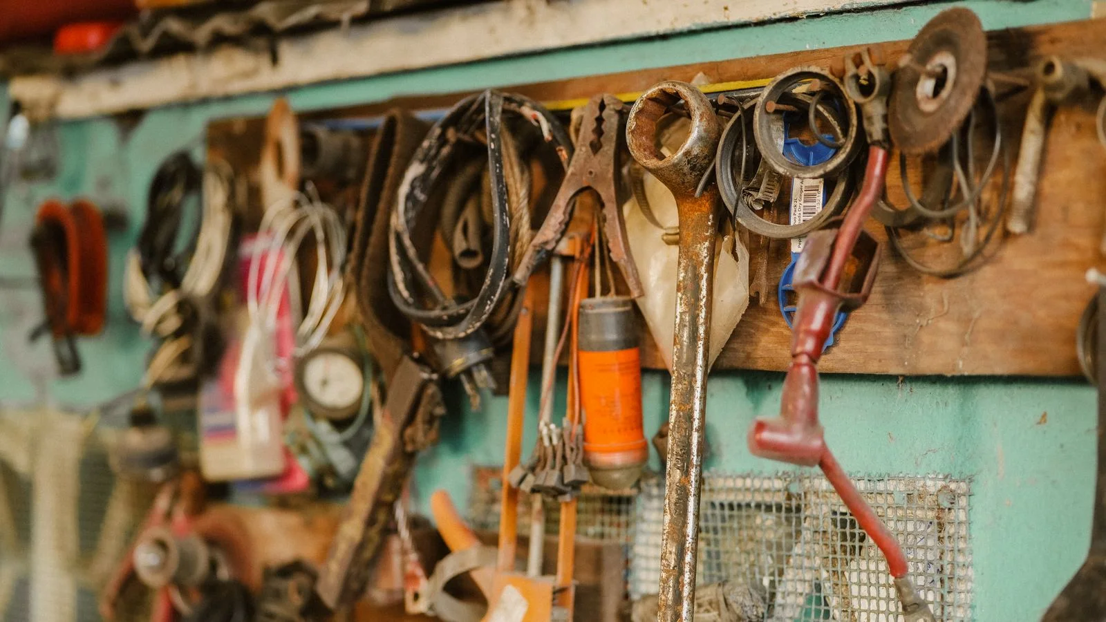 Des outils anciens suspendus au mur d’un atelier, prêts à être repris par la personne suivante.