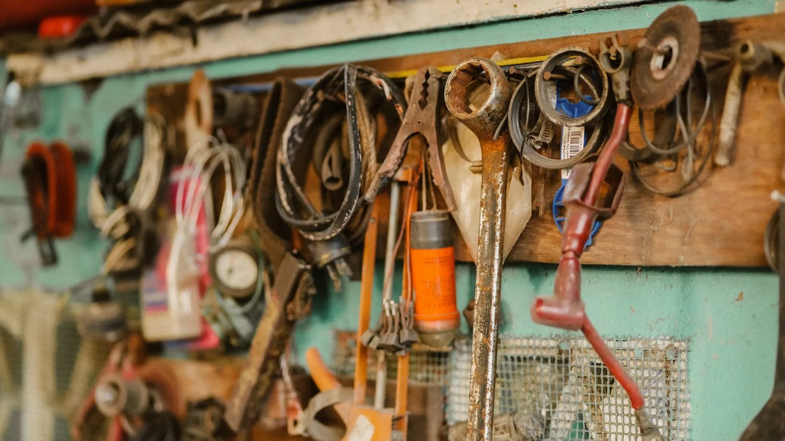 Des outils anciens suspendus au mur d’un atelier, prêts à être repris par la personne suivante.